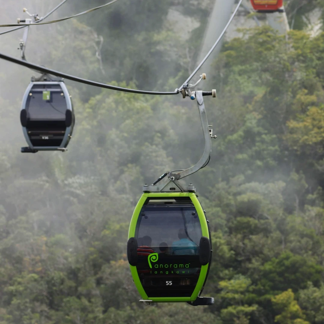 Green Panorama Langkawi SkyCab gondola ascending through the mist above Mount Machinchang rainforest