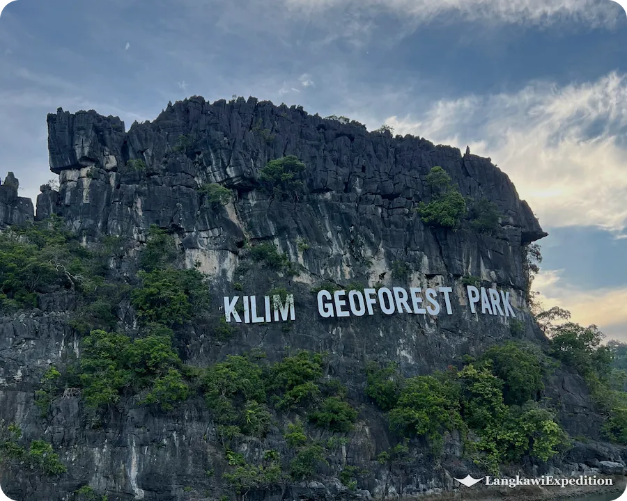 Massive Kilim Geoforest Park landmark sign on a limestone karst cliff