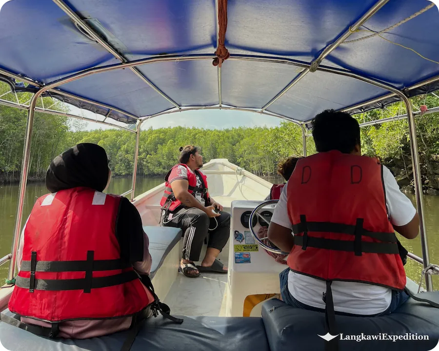 Passengers in life jackets enjoying a private boat tour along Kilim mangrove river